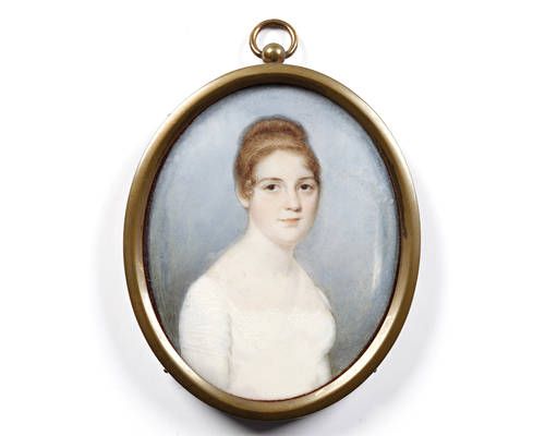 A Lady, wearing white dress with lace trim to the décolleté and sleeves, her brown hair upswept